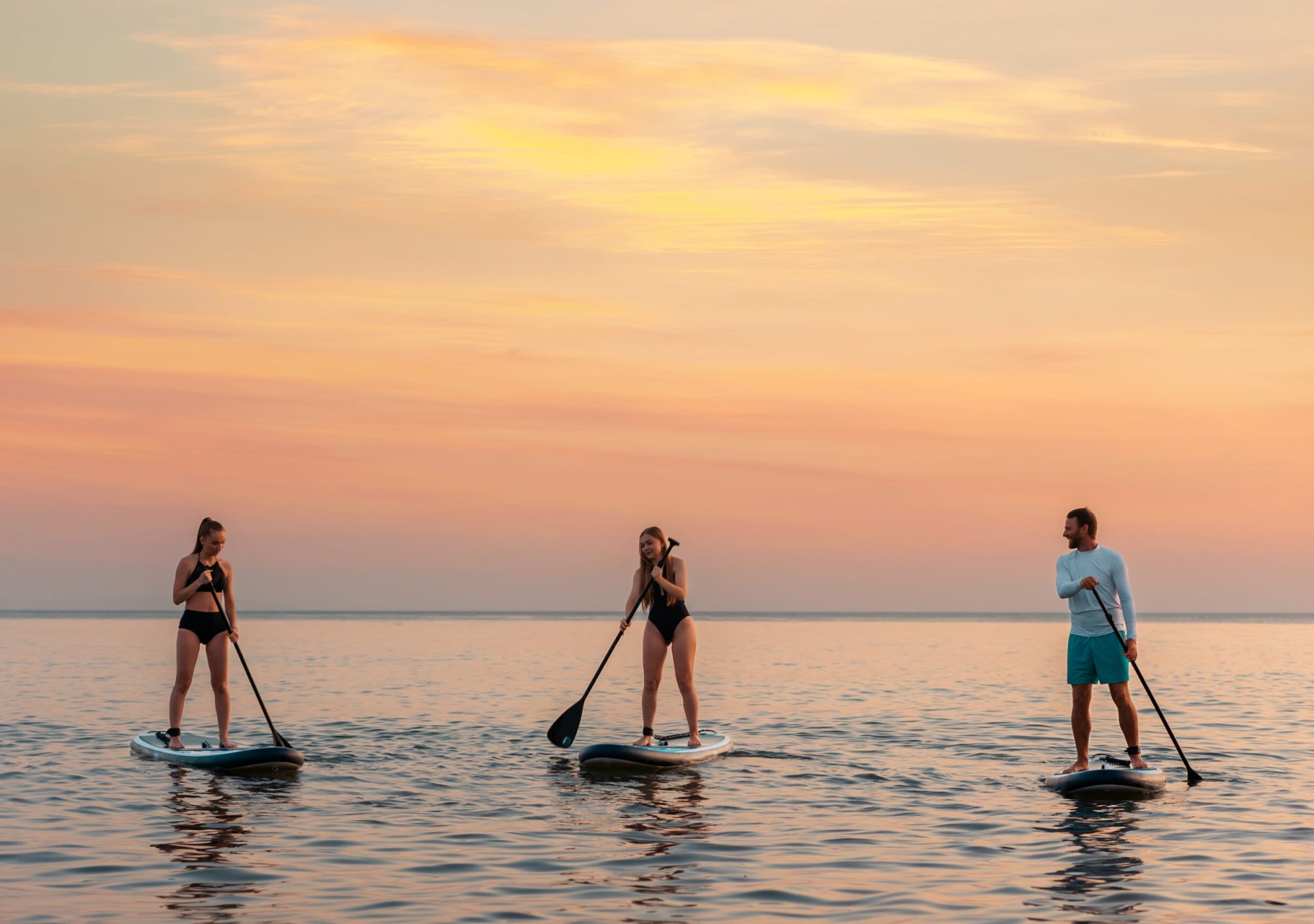 SUP-Stand-up-paddling-meer-Sonnenuntergang-freunde-iStock-1383825934_dw2zbe